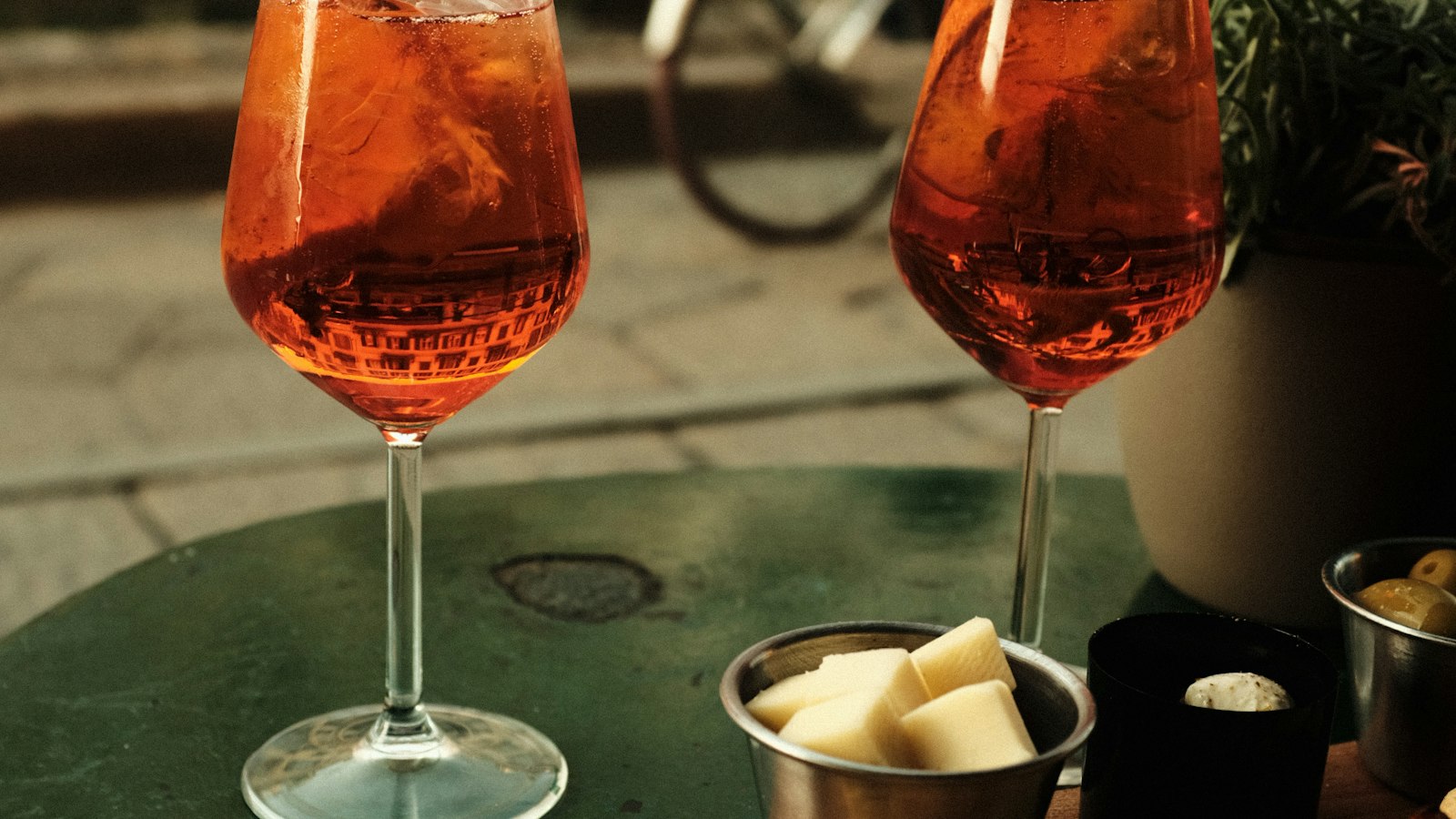 Two spritz glasses on a café table at aperitivo time